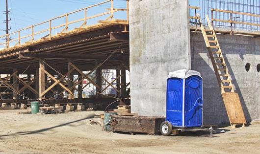 portable restrooms lined up neatly, ready to serve job site workers